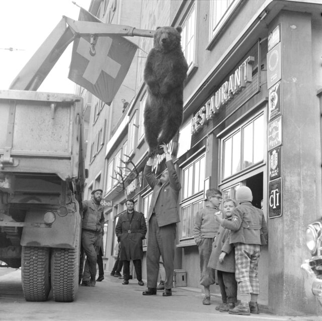 Bär an Haken, vor dem Restaurant, mit 3 Kindern