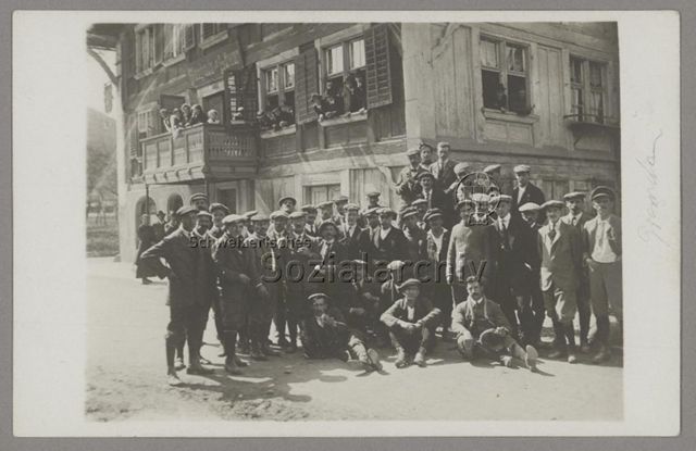 Eine Gruppe Männer mit Schirmmützen posieren vor dem Berghaus zum Löwen in Grenchen, um 1925, Vorderseite handschriftlich beschrieben mit "Grenchen"